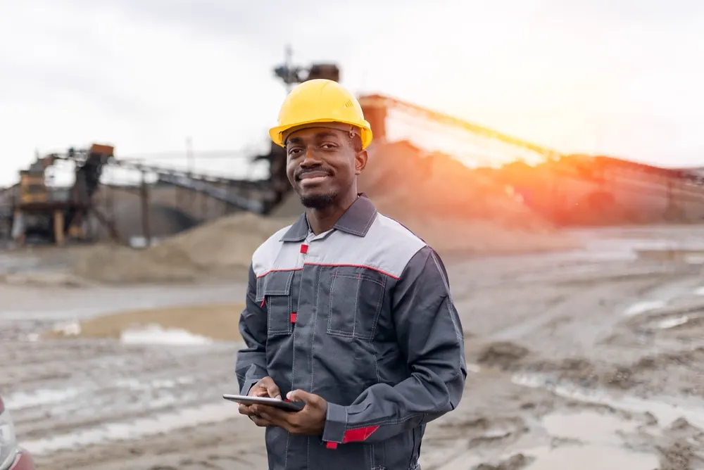South African worker on site reviewing payroll on a tablet